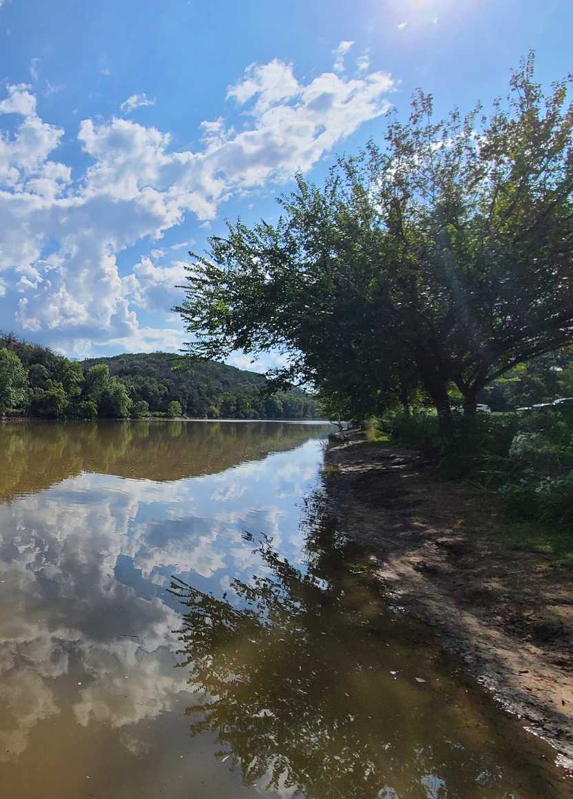 A view of the Colorado River with a reflection of a hill in the water.