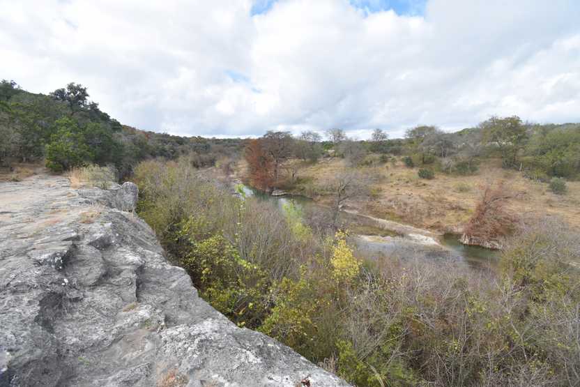 Looking at a view of a valley from a rock ledge.
