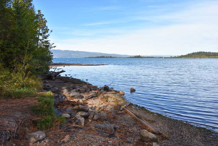 The shore of Flathead Lake. The lake is large is a beautiful blue color.