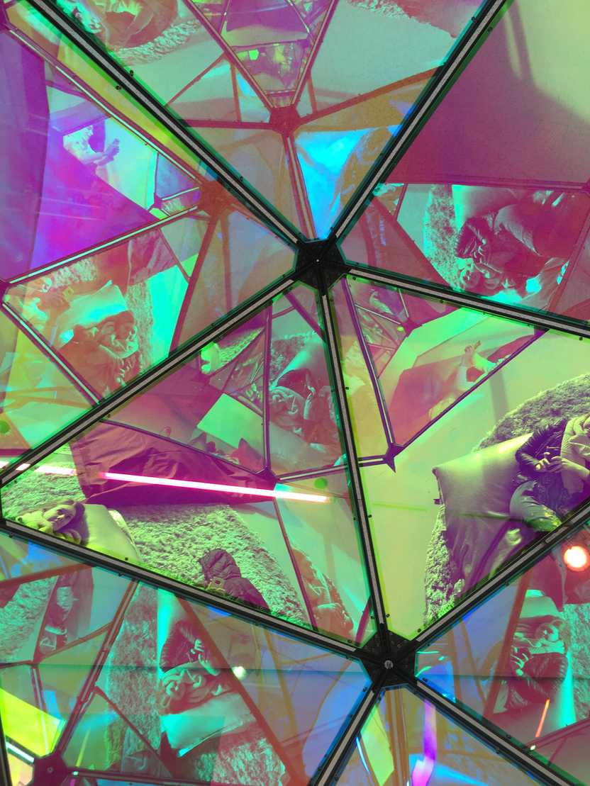 Looking up a geometric mirror in the UnMuseum area of the CAC. You can see Lydia's reflection as she lays on a pillow on the ground, but it's hard to make out.