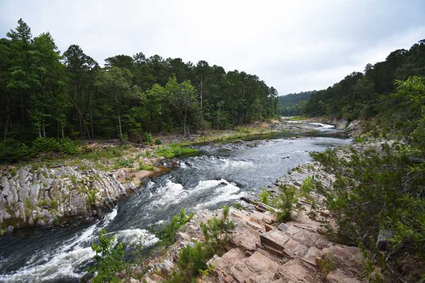 A river surrounded by rocks and trees in Beaver's Bend State Park.
