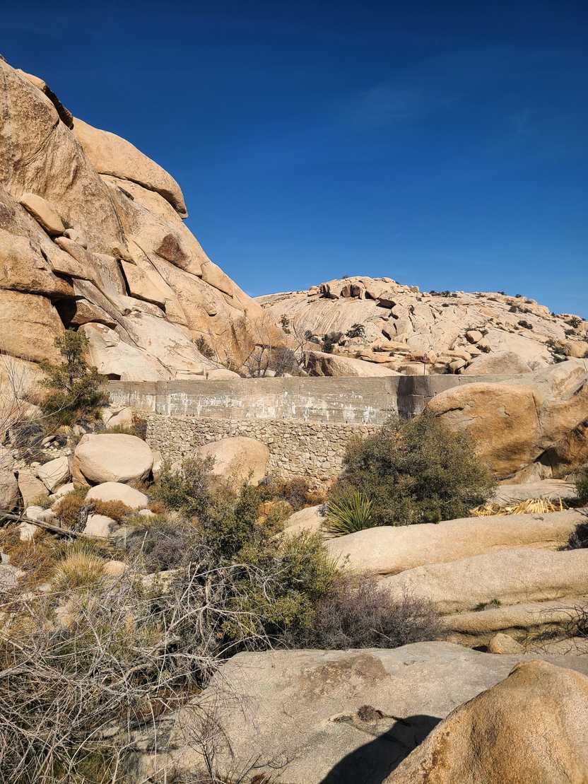 A dam that blends into an area of tan boulders.