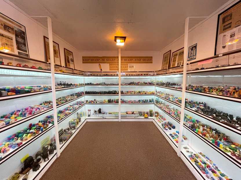 A small room with glass cases full of pencil sharpener's on every wall.