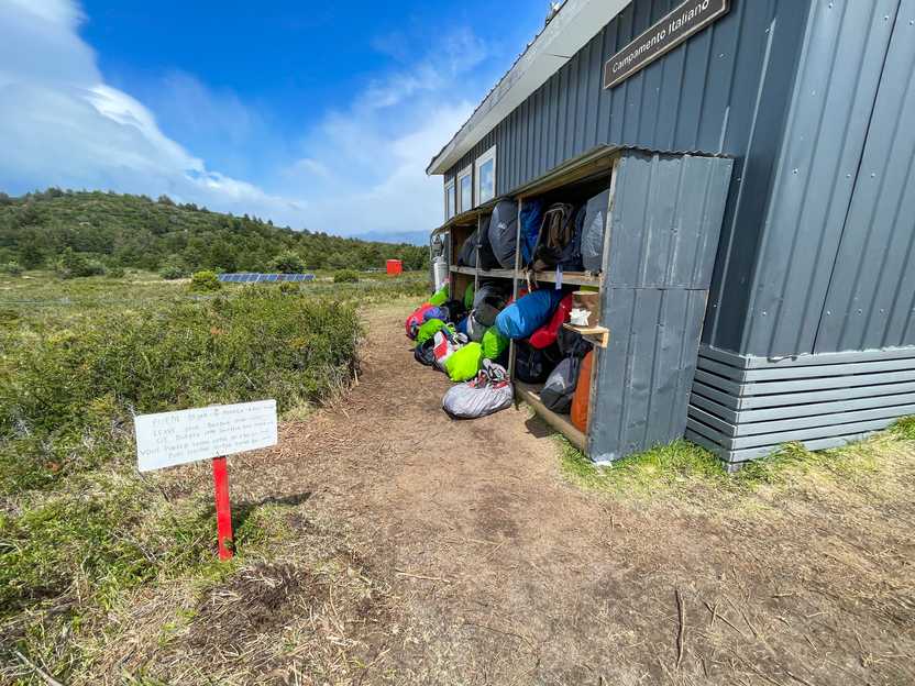 Several hiking backpacks placed in outdoor shelves at the base of French Valley.