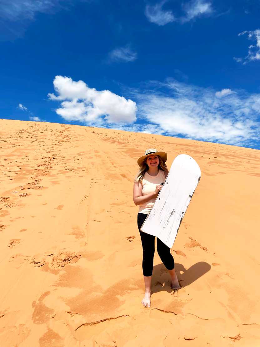 Lydia holding a sand sled at Coral Pink Sand Dunes. Lydia holding a sand sled at Coral Pink Sand Dunes.