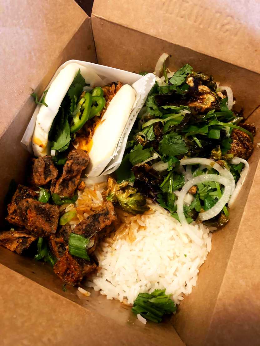 A bento box from East Side King that includes rice, bao buns and more.