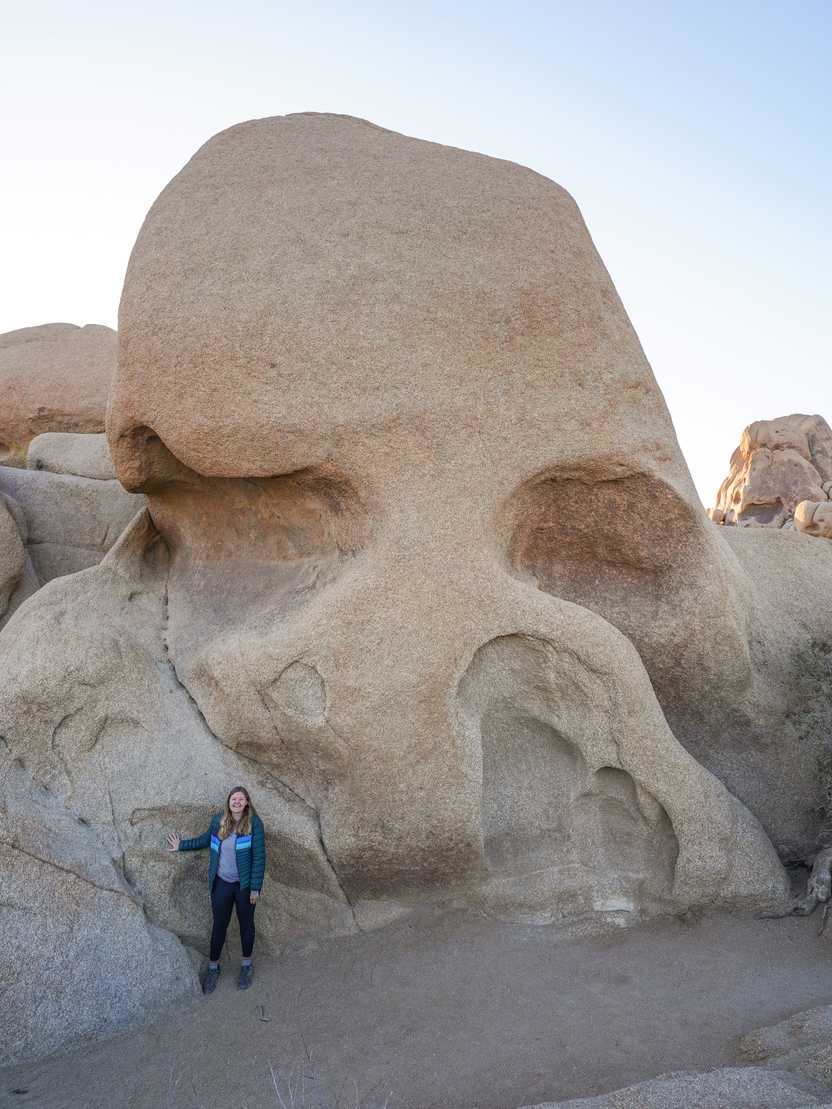 Lydia standing in front of a giant rock that resembles a skull.