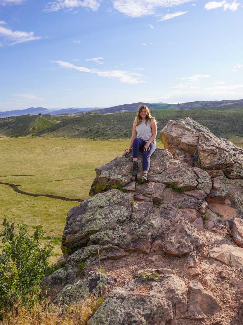 Lydia sitting up on a red, rocky area along the Coyote Ridge.