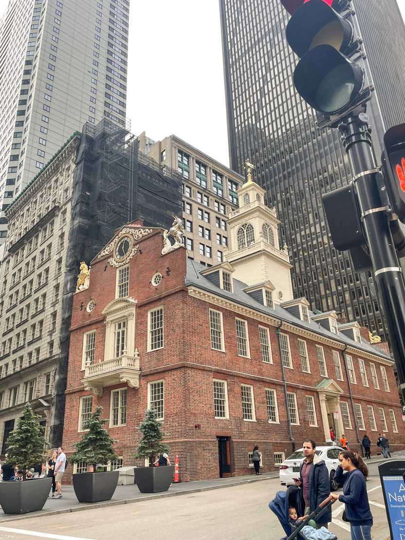An historic brick building next to more modern buildings.