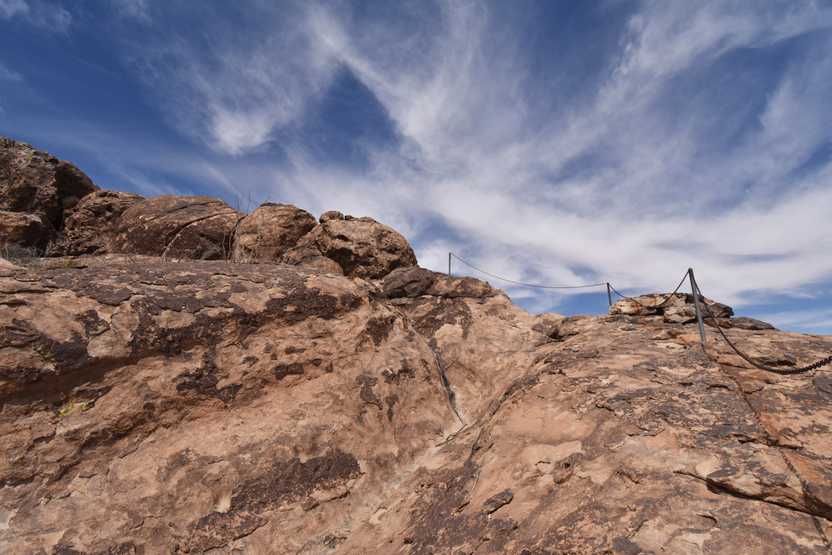 A pole with chains leading to the top of the rock at Hueco Tanks.