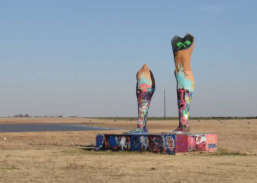A spray painted platform with two legs on top. Both legs are cut off and one is a bit longer than the other.
