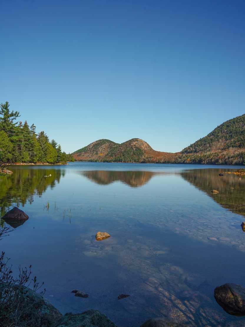 A view of the Bubbles, two mountains that look rounded like bubbles, from across a lake.