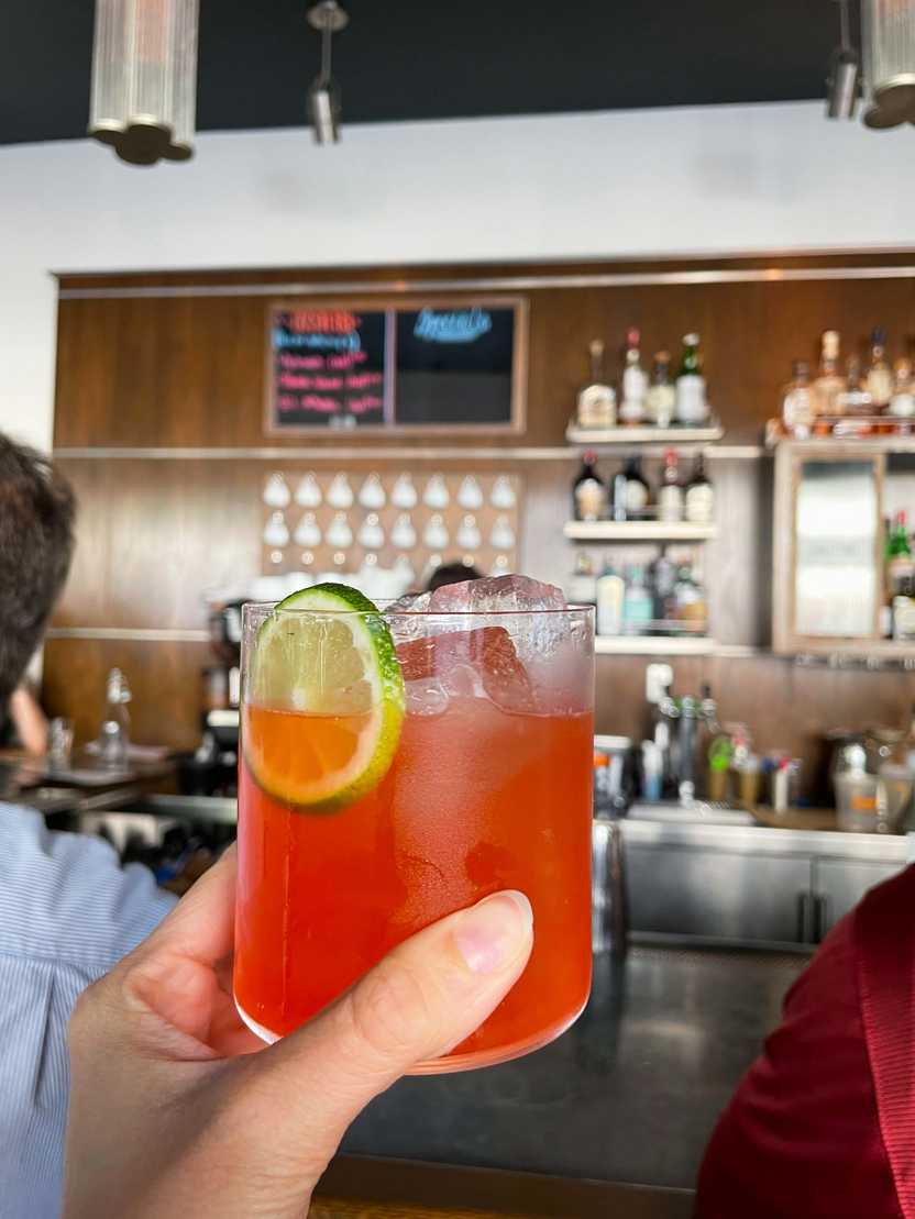Holding up a cocktail inside of The Grey