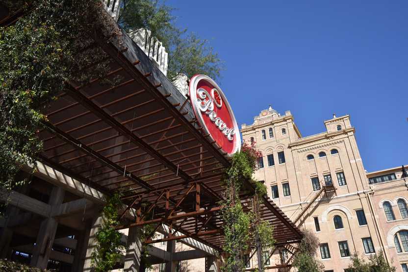 A brown structure with vines hanging from it. There is a red sign that reds 'Pearl'