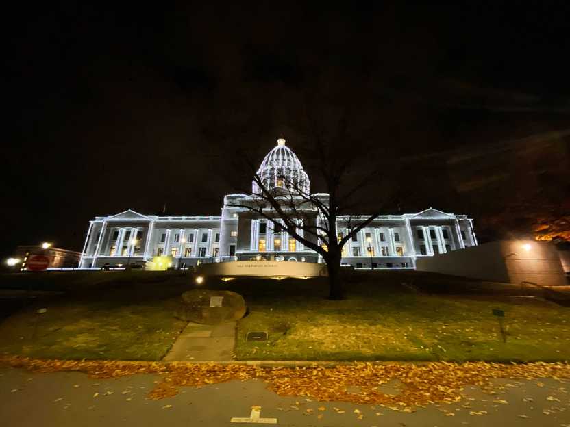 The Little Rock capital building lit up in white lights at night.