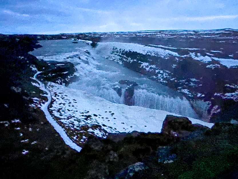 Looking down at a huge waterfall in dim lighting.