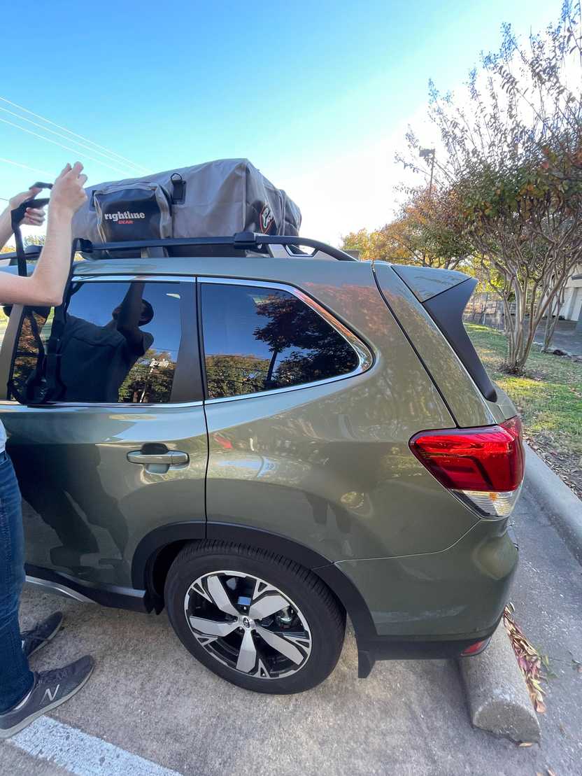 Joe strapping down our soft side rooftop bags to the Subaru Roof rack