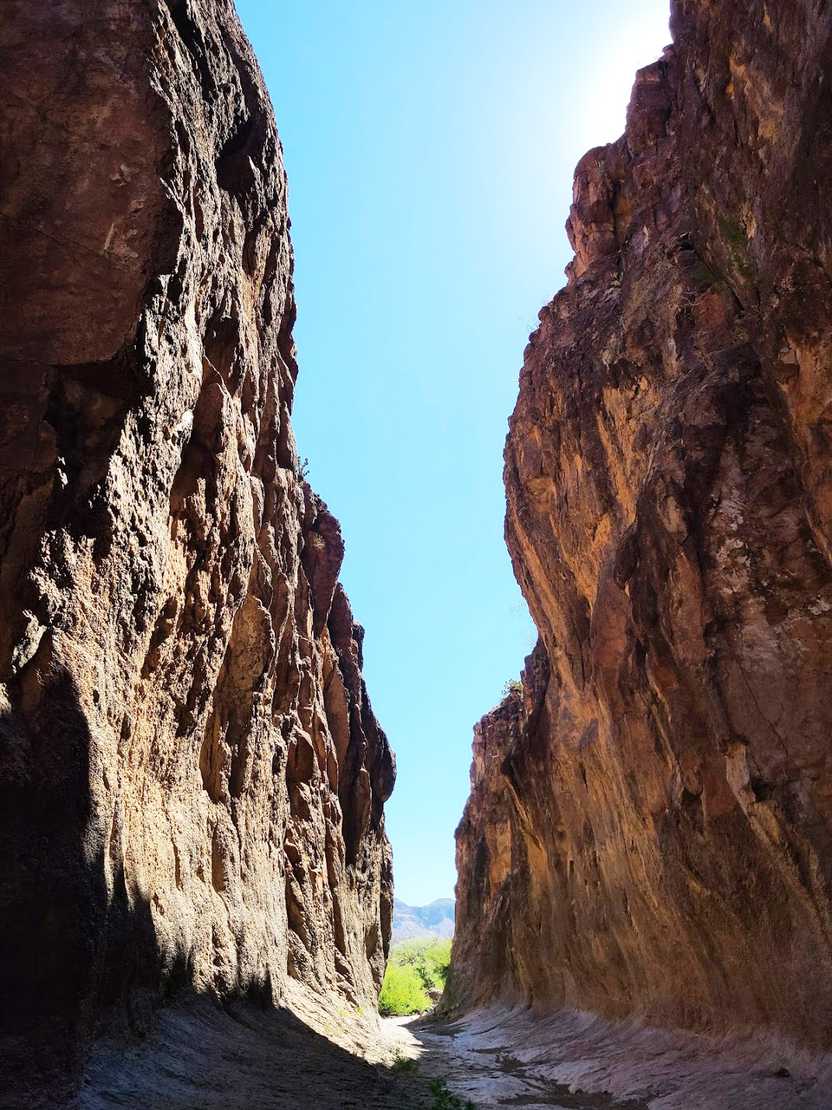 A view inside the slot canyon of towering canyon walls on either side.