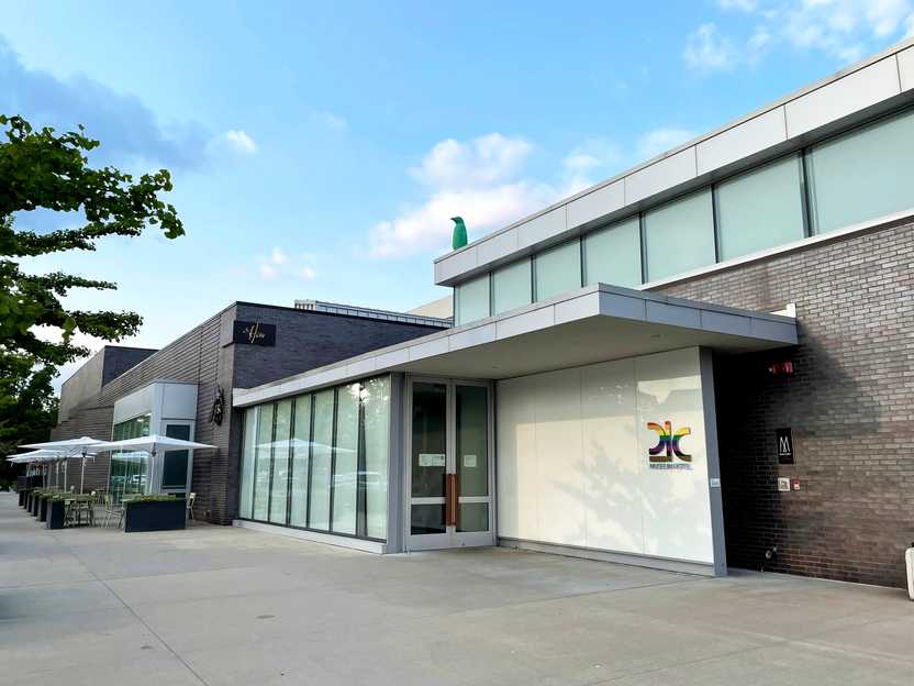 The exterior of the Bentonville 21C. It is a brick building with some large windows and 21C is written in rainbow letters.